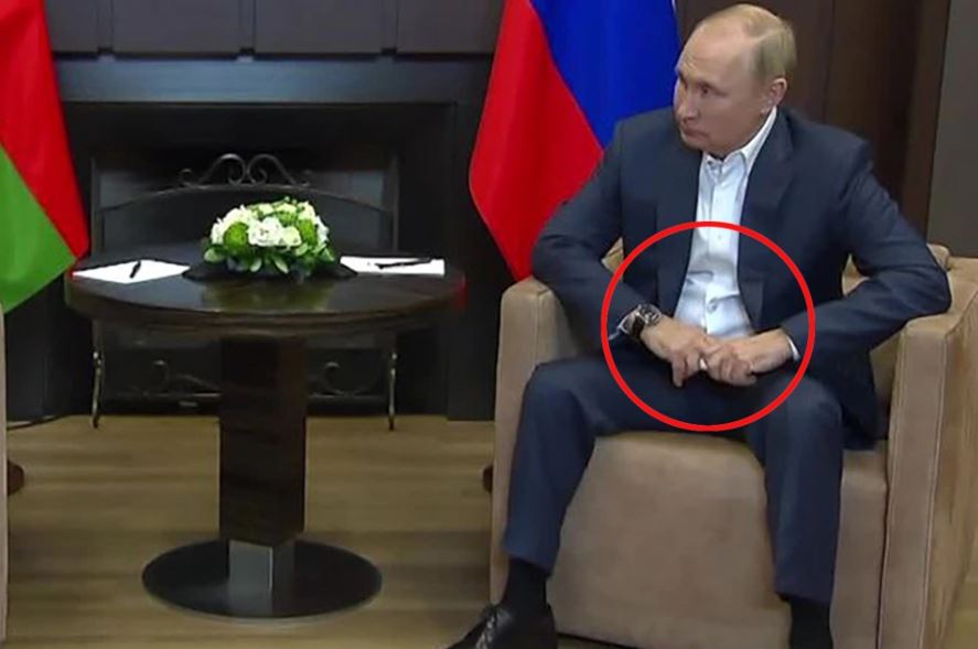 Analysts note how Putin leans forward and clenches his fists 'in pain' during meetings