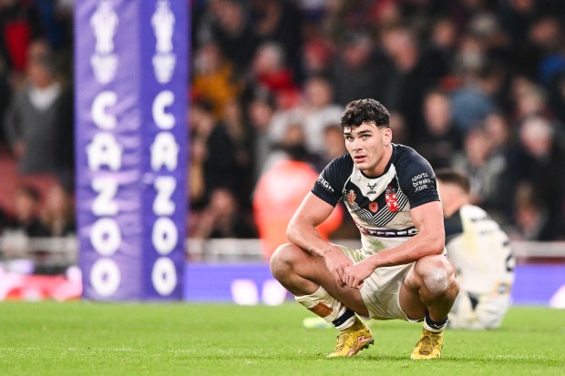 a rugby player is squatting down on the field