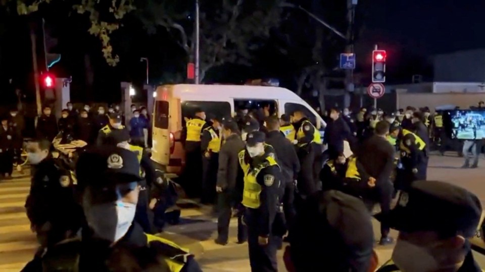 Cops detain people during a protest against Covid lockdown rules