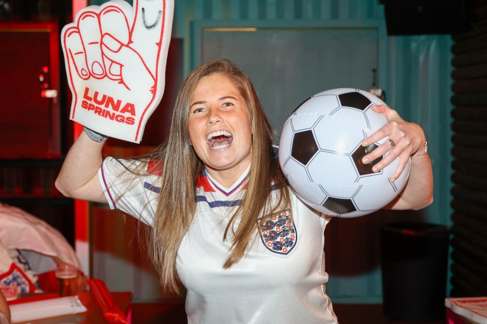 An excited fan clutching an inflatable football ahead of the game