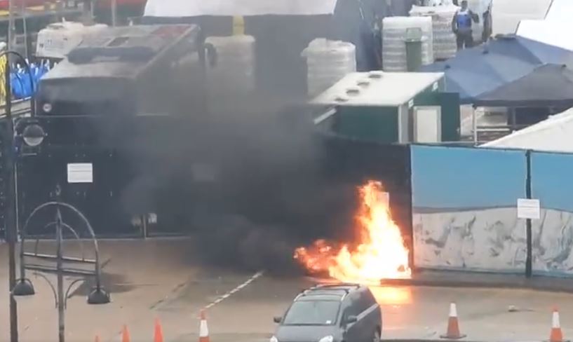 A flame engulfs a gate outside the migrant processing centre in Dover