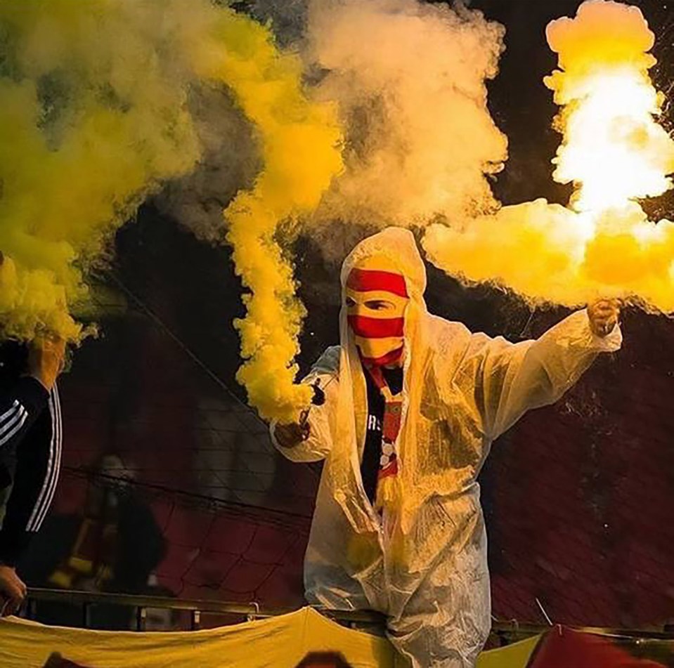 An Arsenal Tula fan lighting up flares during a match