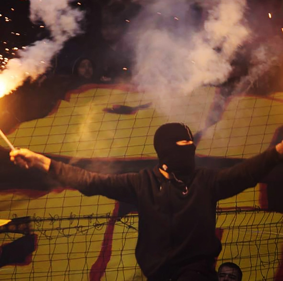 A Russian football hooligan hiding his identity during lunatic behaviour unfolding in a stadium.