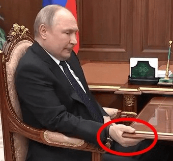 Putin seen 'in pain' and gripping a table during a televised meeting