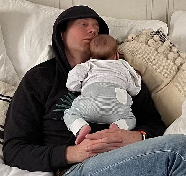 Jack Brooksbank cuddles son August on a sofa at Frogmore Cottage