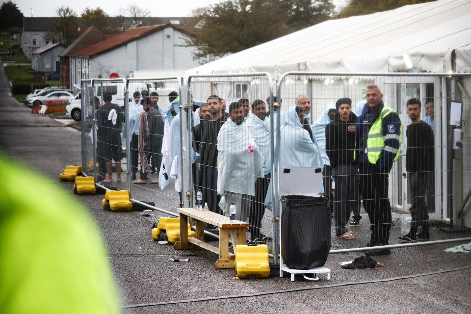 People stand inside a fenced off area inside the migrant processing centre in Manston, Britain