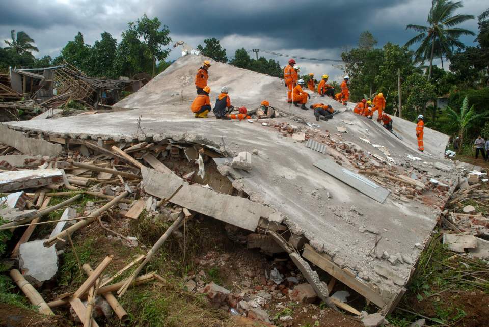 Rescue workers search for victims under the ruins of collapsed buildings in Cianjur