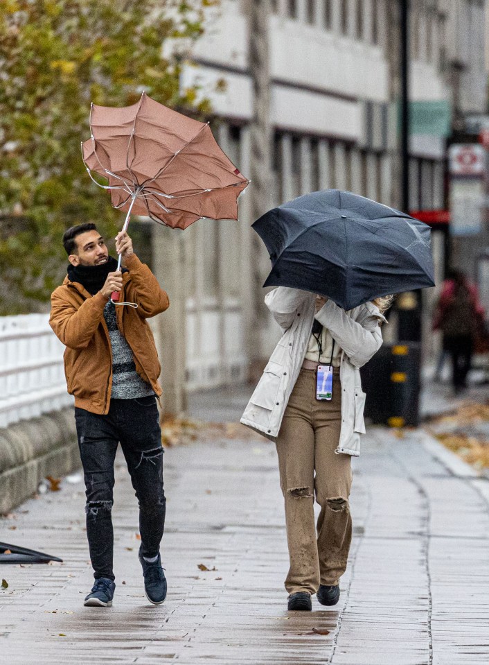 Christmas shoppers battle against the wind and rain on Waterloo Bridge, London