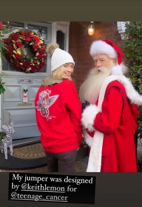 The pair looked typically festive as they posed for a picture outside her front door, adorned with a stunning seasonal wreath