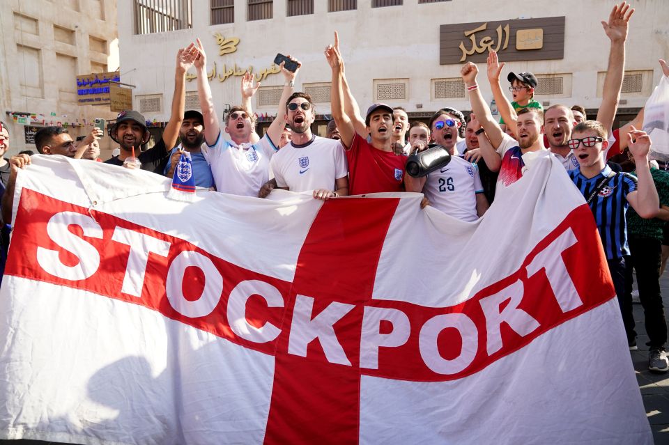 Three Lions fans wave a Stockport County flag ahead of the last-16 tie