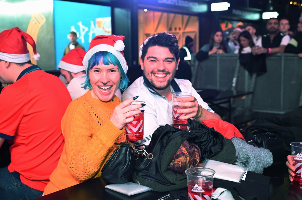 Grinning fans posing with their pints at Boxpark Wembley