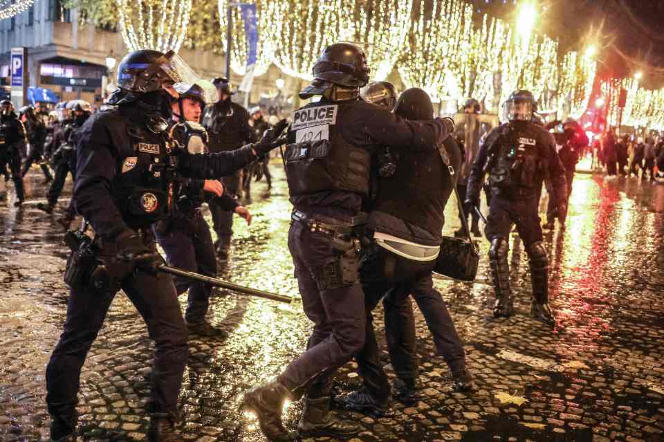 French police officers confront a fan on the Champs-Elysees in central Paris