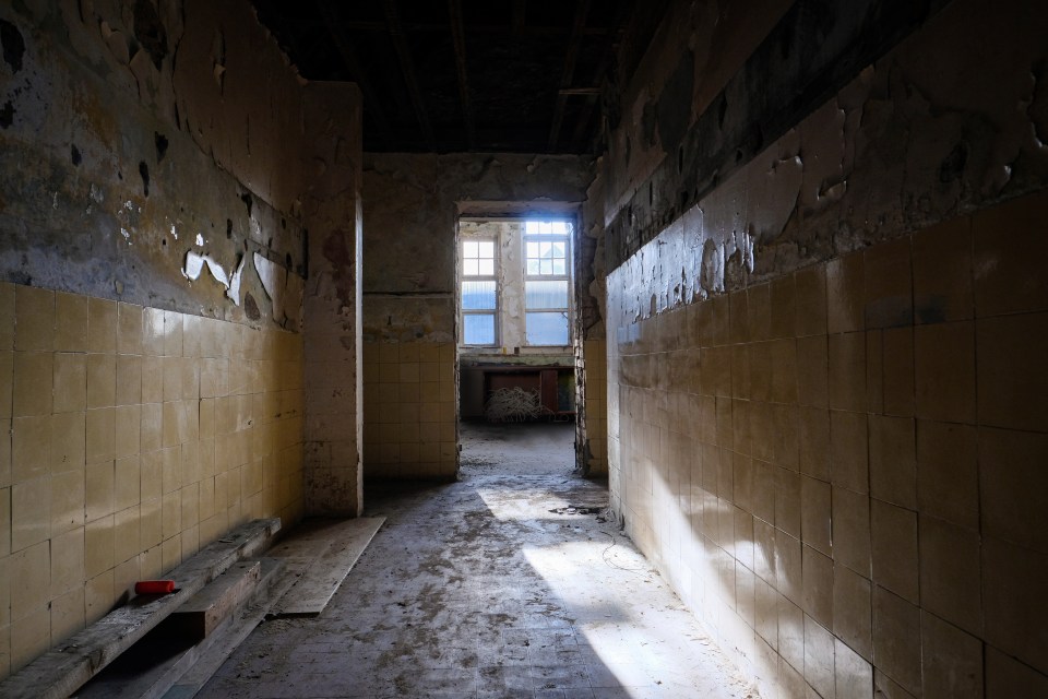 The floors appear covered in dust while tiles have been stripped from the walls