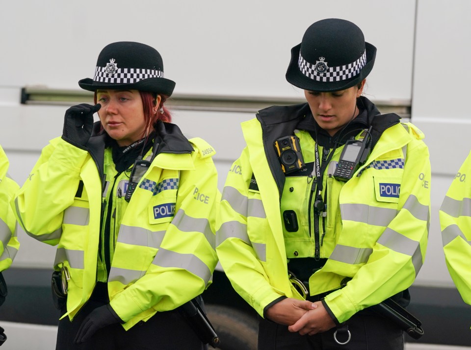 An officer cries as the emergency workers pay their respects to the dead children