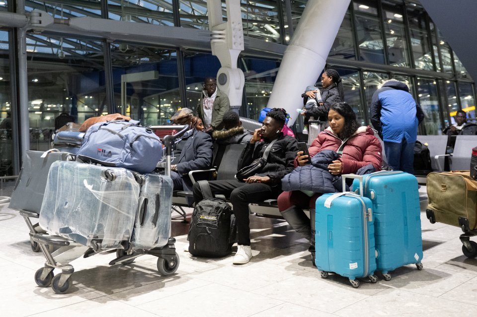 Travellers wait with their luggage at Heathrow terminal 5 amid chaos at UK airports