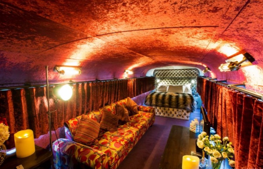 The bedroom is lined with red velvet fabric on the walls and ceilings