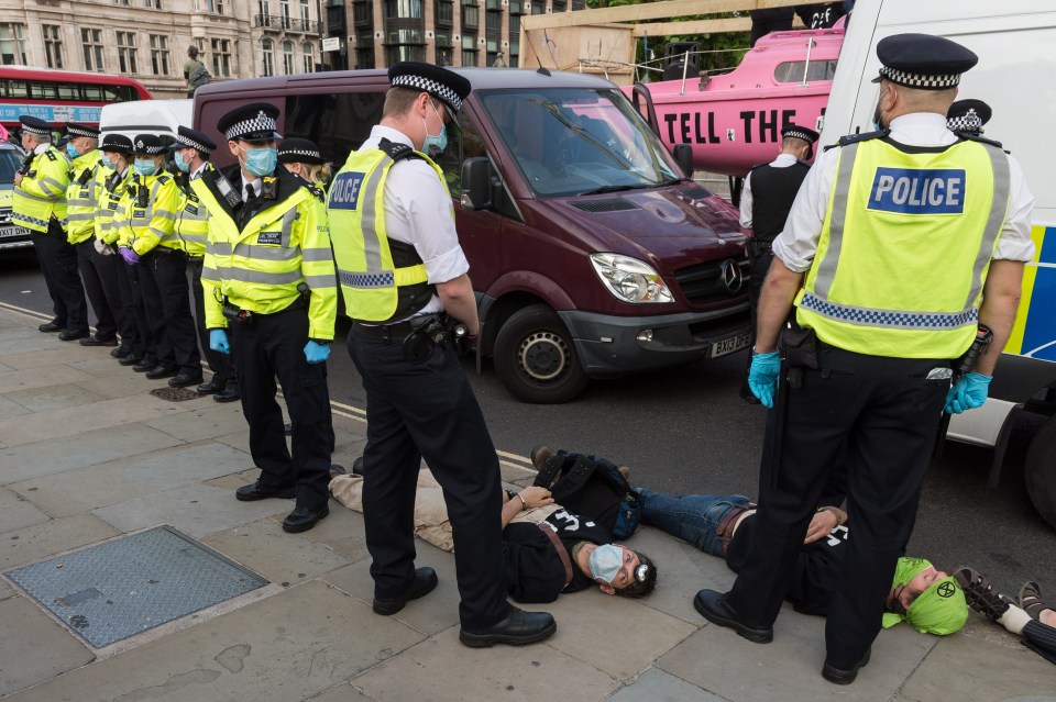 Extinction Rebellion activists lie on the ground after being arrested in London