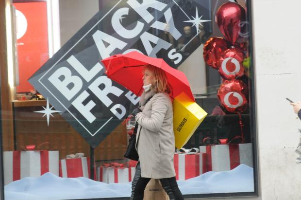 a woman walking in front of a black friday sign