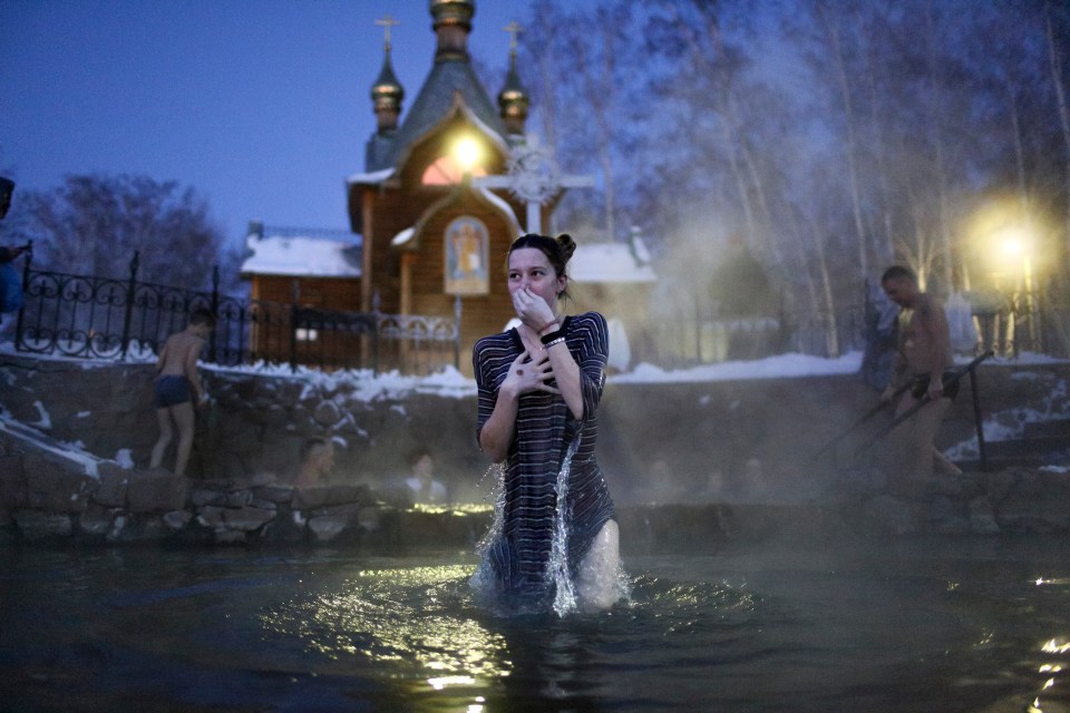 A woman bathes in freezing water during a traditional Epiphany celebration