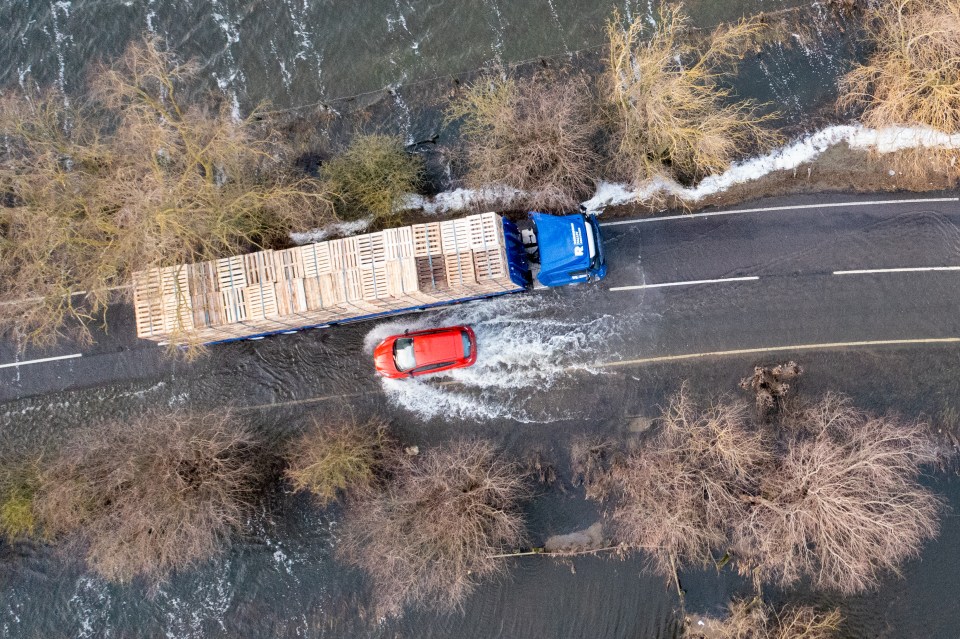 Vehicles going through the flooded A1101 in Welney on the Norfolk/Cambridgeshire border on Wednesday morning