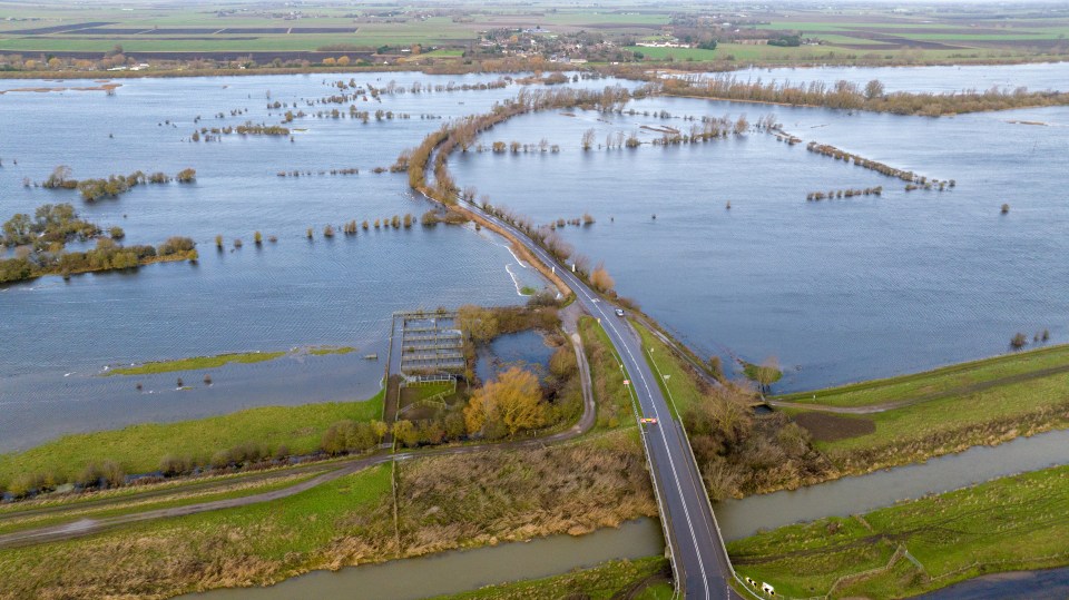 Vehicles going through the flooded A1101 on the Norfolk and Cambridgeshire border