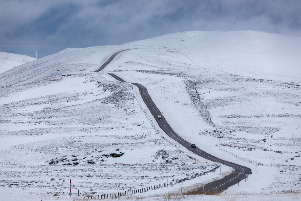 Cars make their way along the A939 after heavy snowfall in the Scottish Highlands