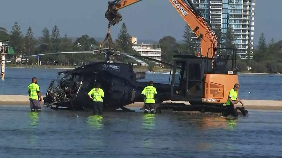 Emergency workers remove a damaged chopper from the sandbank