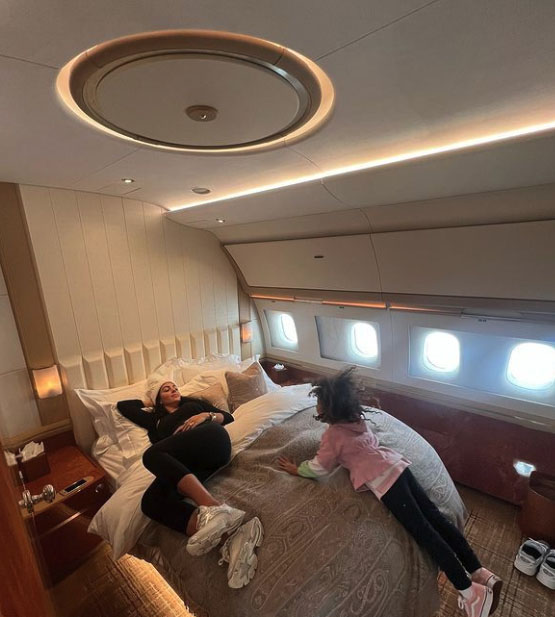 Georgina relaxed on a big bed as they flew to the Middle East