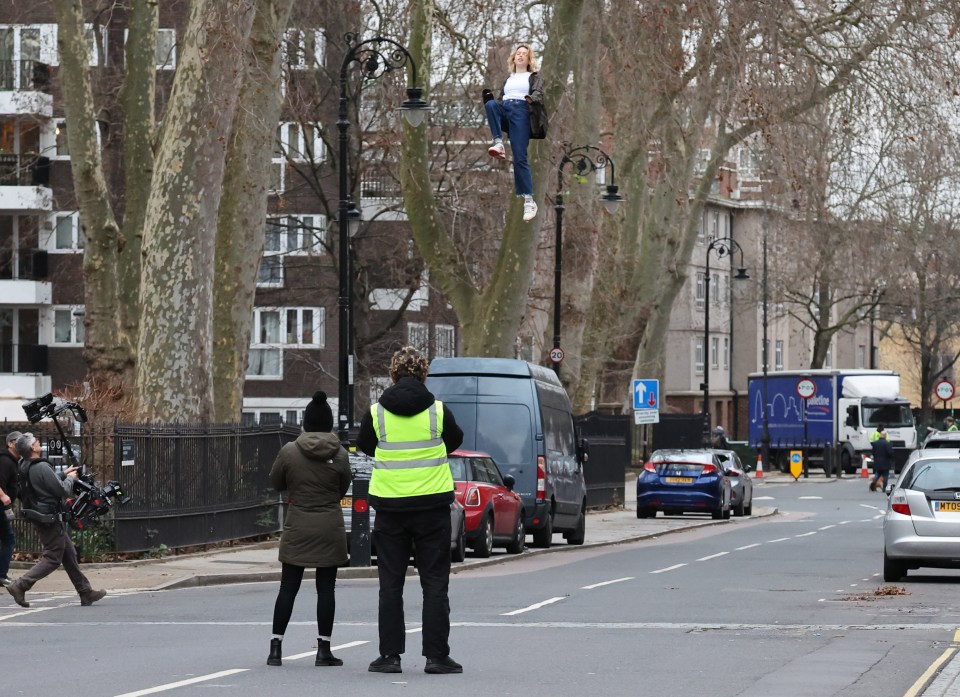 Milly soars into the sky above cars and passers-by