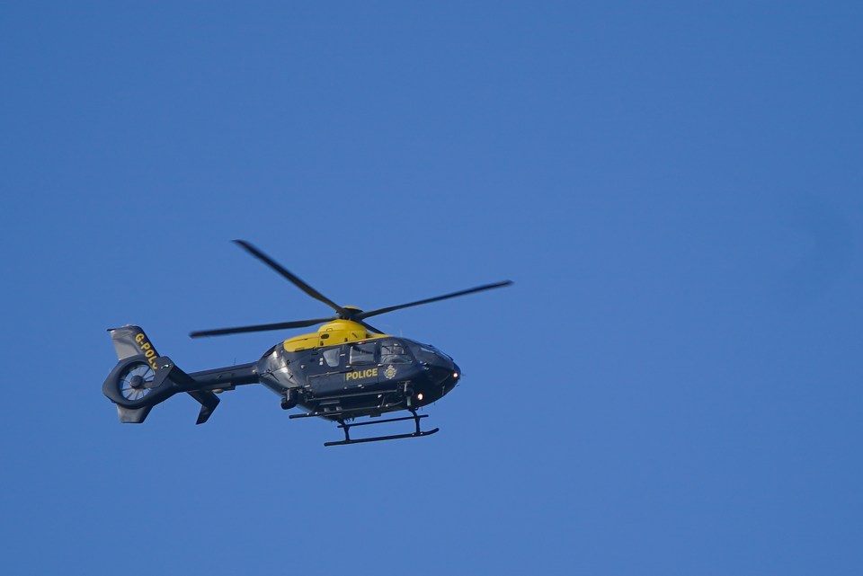 A police helicopter scours the scene