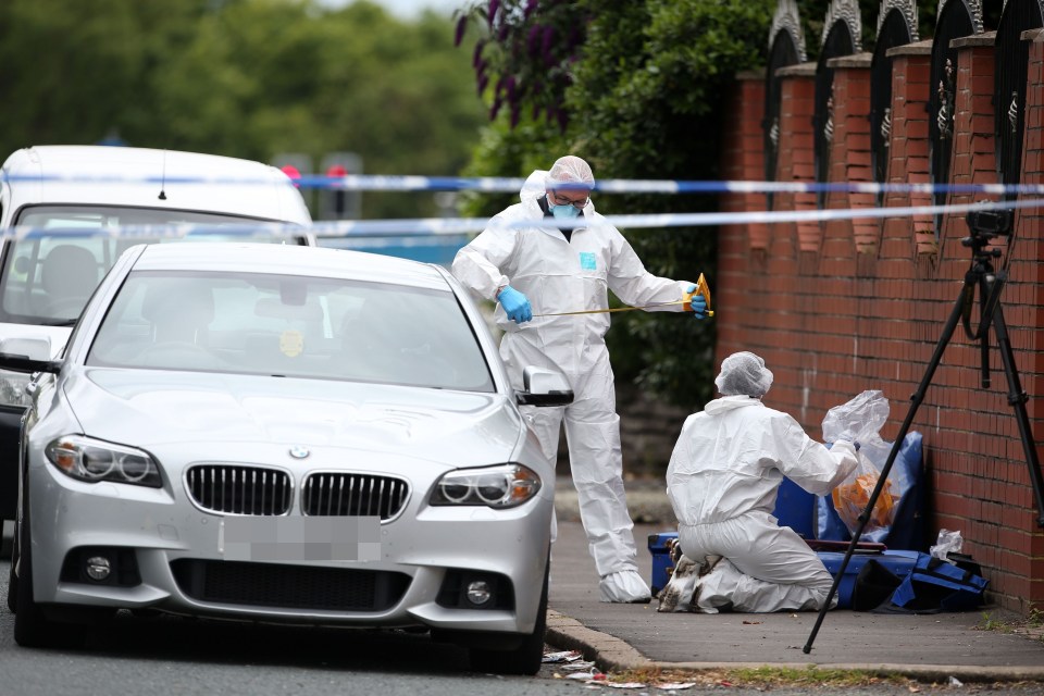 Police at the scene in Manchester Road, Salford, after businessman Paul Massey was shot dead at his house by a lone masked gunman