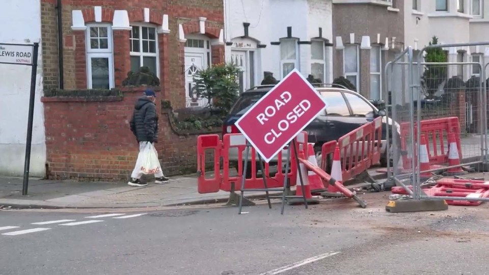 A pedestrian walking behind a car which has ignored the road signs and barriers