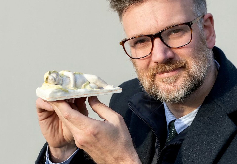 Auctioneer Charles Hanson holds the porcelain figure