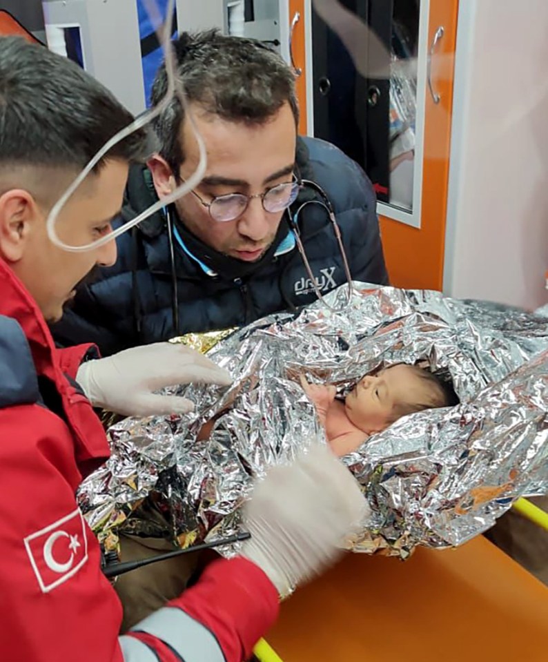 Ten-day-old baby Yagiz Ulas pictured with rescuers