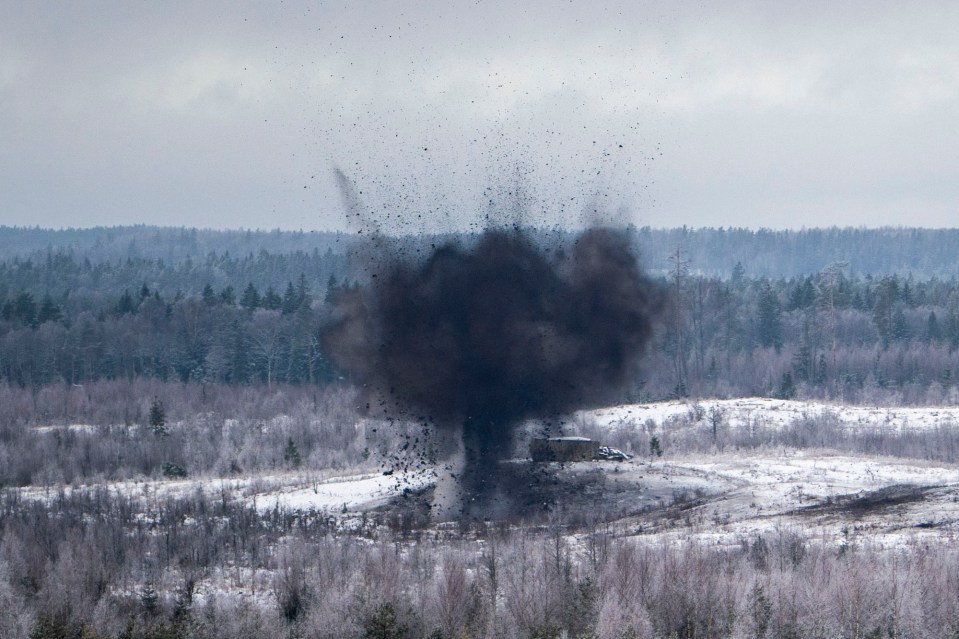 Artillery shells burst on a target during the exercises