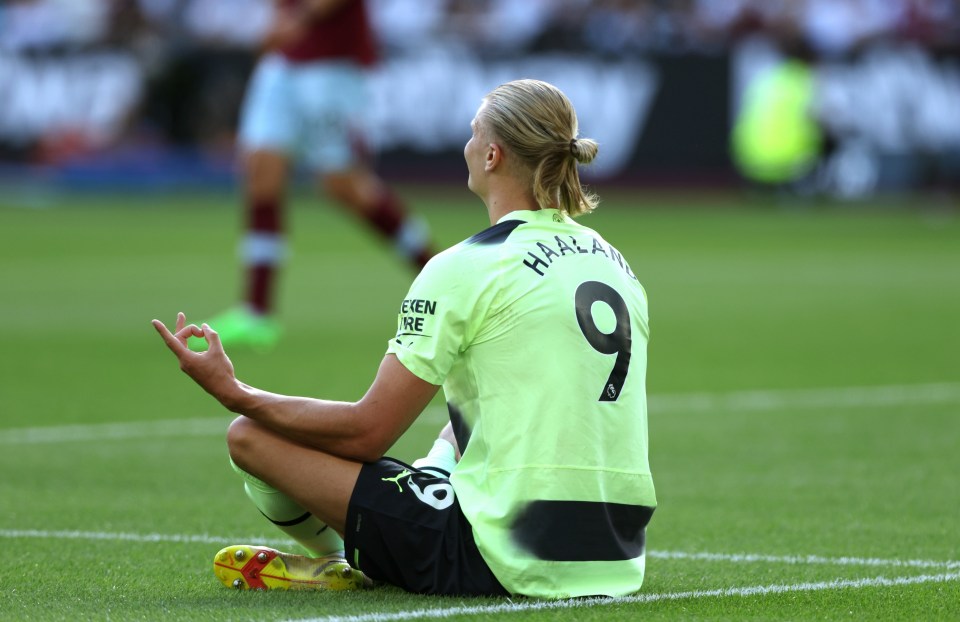 a soccer player with the number 9 on his back sits on the field