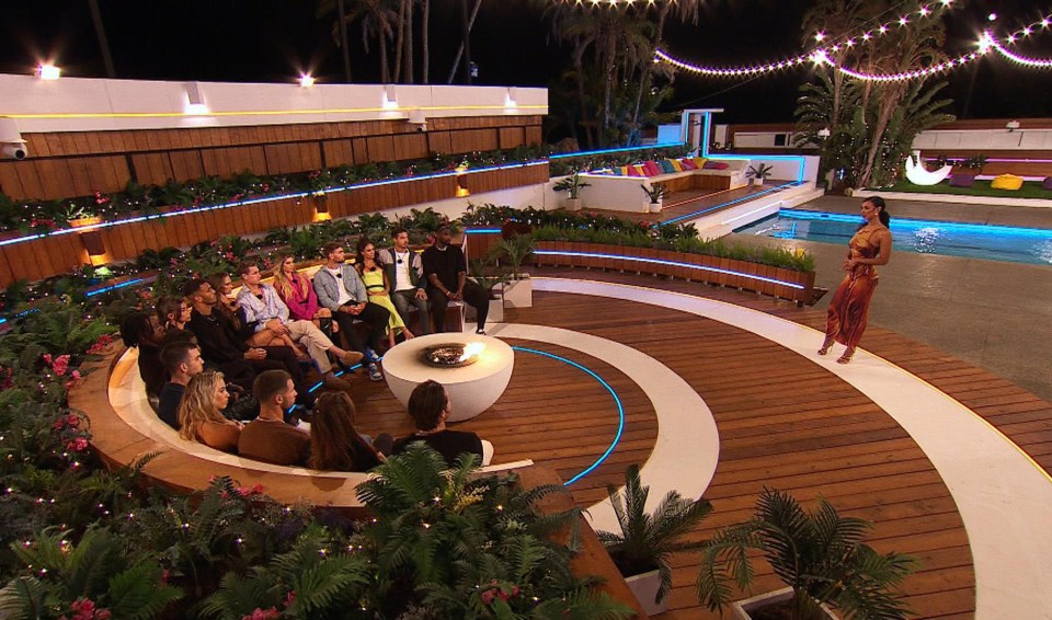 The contestants gather around the fire pit