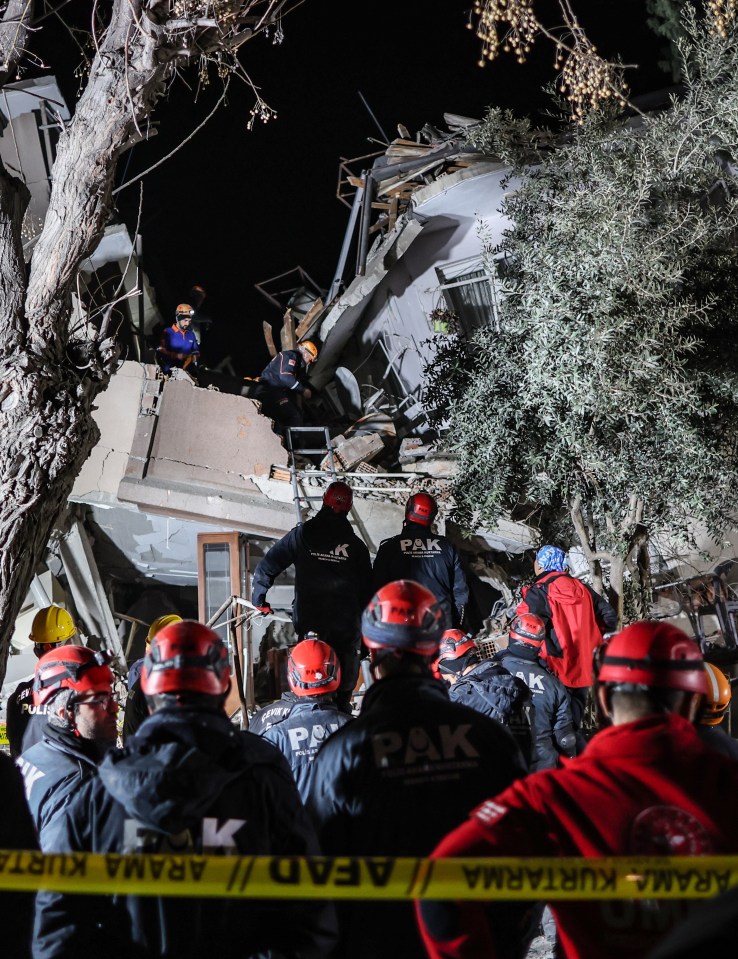 Rescue workers search through a collapsed building in Hatay