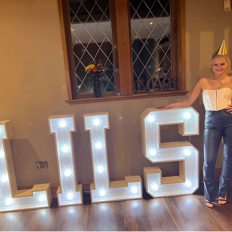 The pantomime actress posed next to a bespoke light display at her birthday bash