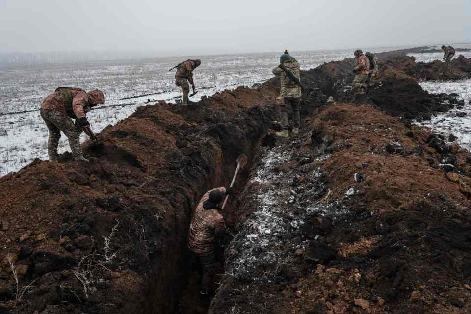 Outside the city, Ukrainian servicemen dig trenches in Bakhmut's frozen ground