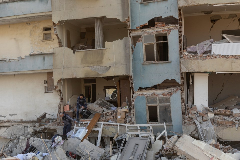 Arsin and his father take their belongings out of their destroyed apartment