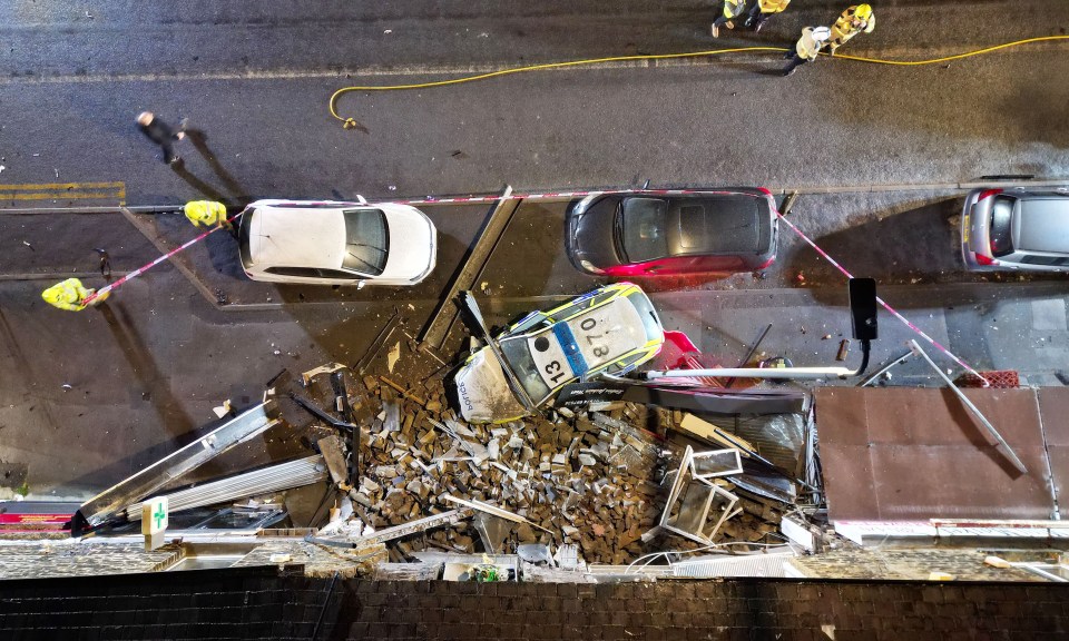 Two vehicles crashed leaving shops damaged and debris strewn across the road