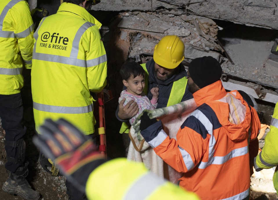 A young boy pulled out of the rubble by rescuers