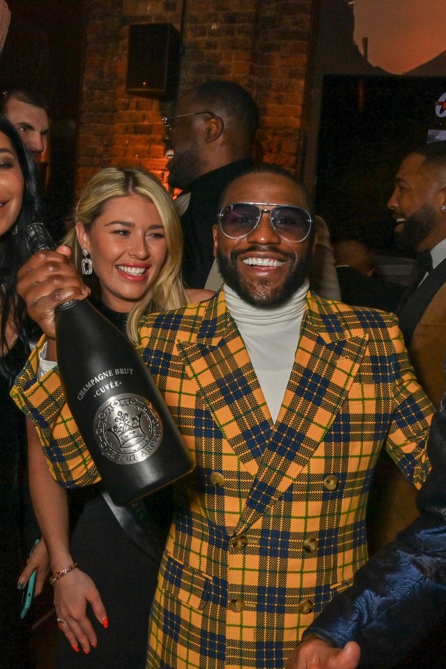 Floyd Mayweather gleefully clutches a bottle of champagne