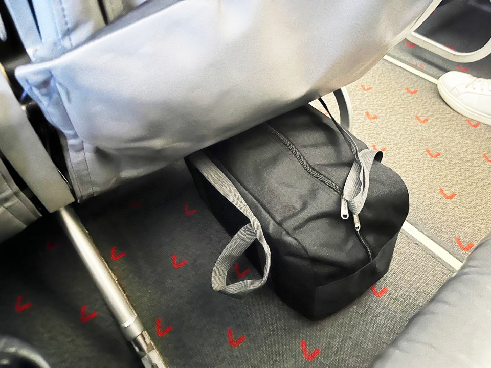 a black bag sits on a carpet with red arrows on it