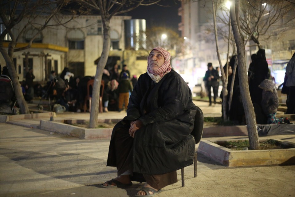 A woman sits in the safety area of the Al-Bab district of Aleppo following the latest quake to rock the region