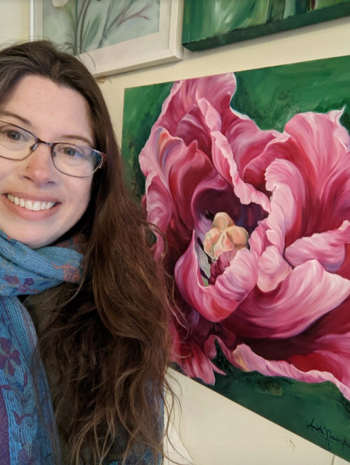 Sharon poses alongside a painting, one of the items she bartered on her way to owning a property