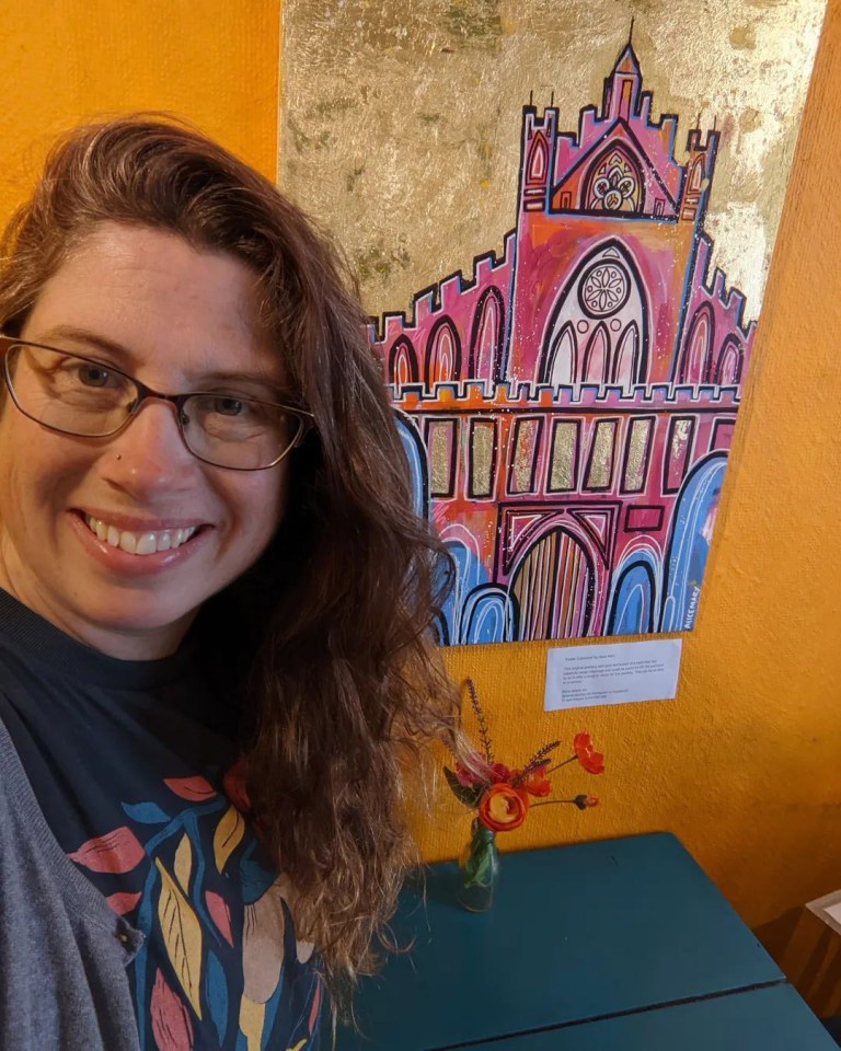 Sharon poses with a painting of Exeter Cathedral