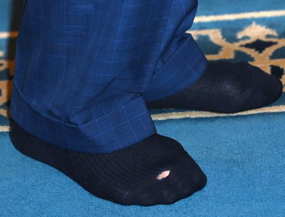 Charles was wearing a pair of sock littered with holes whilst visiting a mosque in London's Brick Lane