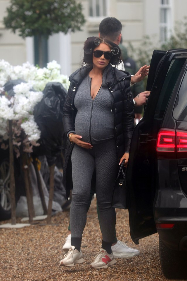 Amy Childs revealed her growing baby bump in a knit grey jumpsuit as she arrived for her baby shower